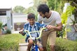 © wavebreak3 - Man assisting son cycling