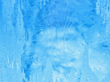 Bright Blue Frost Pattern On The Window Glass (abstract New Year Or Winter Background)