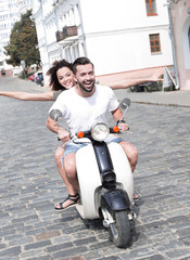 Happy young couple having fun on a scooter