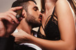 © LIGHTFIELD STUDIOS - handsome businessman with cigar kissing beautiful girl in lingerie