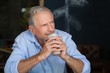 © WavebreakMediaMicro - Senior man looking away while holding cold coffee