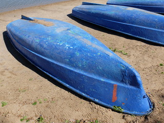 Inverted boats on the sandy shore of the lake