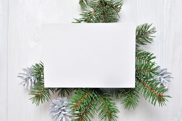 Mockup Christmas greeting card with tree and cone, flatlay on a white wooden background, with place for your text
