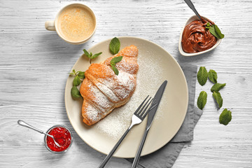 Canvas Print - Plate with delicious sweet croissant on table