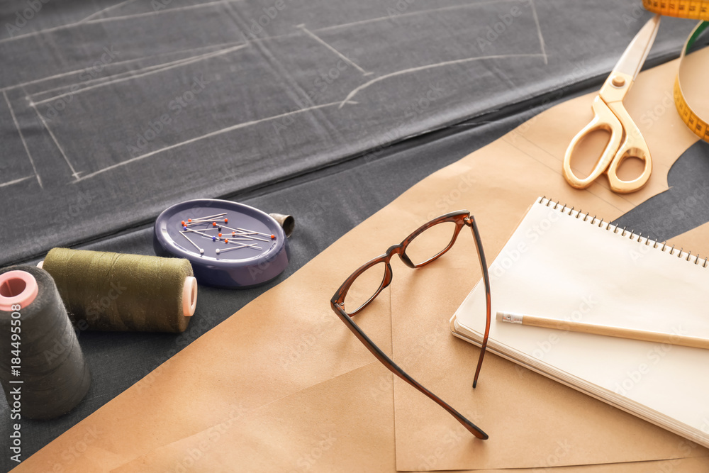 Notebook with sewing accessories on table