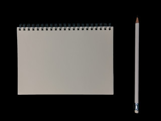 Clear color note book opened for note or lecture note or memo for remine and brown cover whit black head color pencil in white apparel in black background.