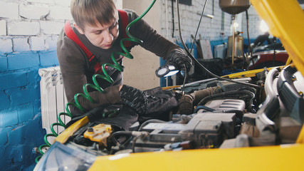 Wall Mural - Mechanic unscrews detail of car in hood - automobile service repairing, close up