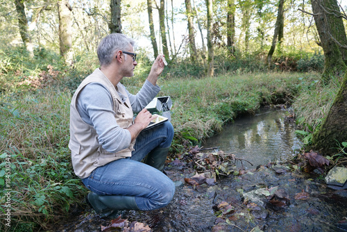 Fotomural Biologist testing water quality of river