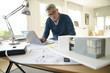 © goodluz - Architect in office working on construction project