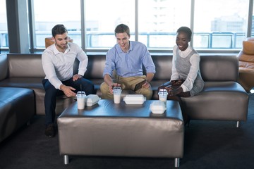 Wall Mural - Male and female executives having snacks