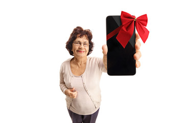 Wall Mural - Mature woman showing a phone wrapped with a red ribbon as a gift