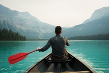 Rear View Of Man Kayaking In Lake