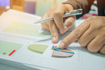 Wall Mural - Businessman Preparing reports papers with graphs, charts on Stacks of documents files for finance in office. Piles of unfinished document achieves with paper clip. Concept of Business Annual Report.