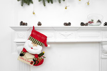 A Close Picture Of Beautifully Decorated Santa Christmas Socks With Ho! Ho! Ho! Word Hanging On A Fireplace Waiting For Presents.