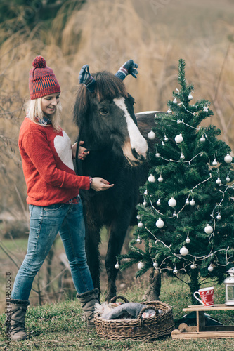 Girl With Horse Decorating Christmas Tree Funny Outdoor Image