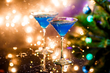 Christmas photo of two wine glasses with blue cocktail and garland