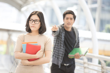 Asian woman walk away from man with angry emotion.