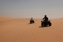 People Driving Four Wheelers On Sand