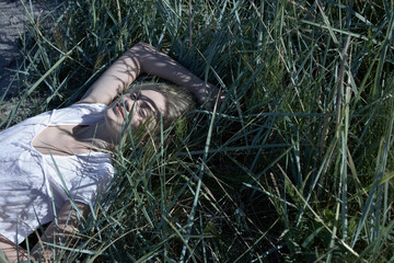 Young woman lying in long grass