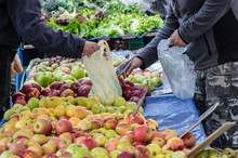 Elderly Person Selecting Fruit On The Street Market