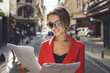 © xo4uphoto - Fashionable woman reading some papers and smiling