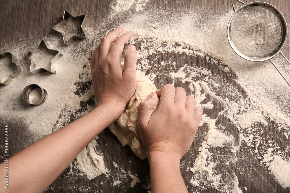 Woman kneading puff pastry on table