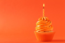 Tasty Cupcake With Candle On Orange Background