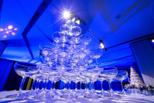 Pyramid Of Glasses Champagne On Wedding Party. Champagne Tower. Glass Of Tower In Blue Background. Select Focus