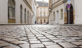 Fototapeta Uliczki - Old street in the historical centre of Prague. Cobblestones close-up.
