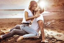 Fashion Shot Of An Attractive Couple Kissing On A Beach