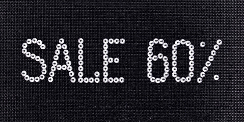 Sticker - Word SALE is made rhinestones crystal color on a black canvas background.