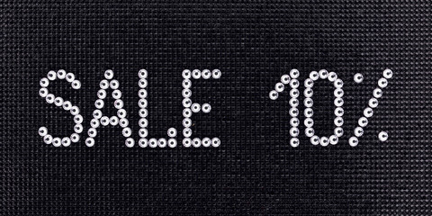 Poster - Word SALE is made rhinestones crystal color on a black canvas background.