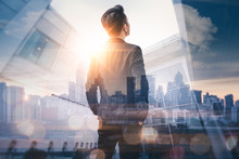 The Double Exposure Image Of The Business Man Standing Back During Sunrise Overlay With Cityscape Image. The Concept Of Modern Life, Business, City Life And Internet Of Things.