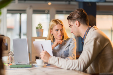 Two business people  discussing about business plans in a cafe.