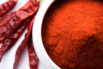 Canvas Print - Red Chilly Powder in a bowl with dried red chillies over colourful background or pile of red chilli powder over plain background

