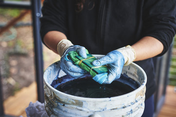 Wall Mural - a woman dying fabric with indigo dye.