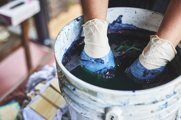 Wall Mural - a woman dying fabric with indigo dye.