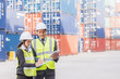 © interstid - Businessman with secretary in logistic, export, import industry checking shipping cargo container freight.