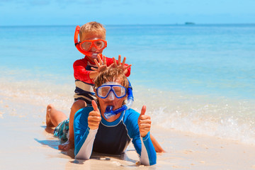 happy father and son snorkeling on beach