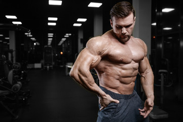 Brutal strong bodybuilder athletic men pumping up muscles with dumbbells.