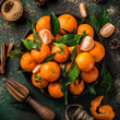fresh clementines (tangerines) with spices on dark greeen background, top view. Winter or Christmas food concept