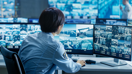 Leinwandbilder - In the Security Control Room Officer Monitors Multiple Screens for Suspicious Activities. He's Surrounded by Monitors and Guards Facility of National Importance.