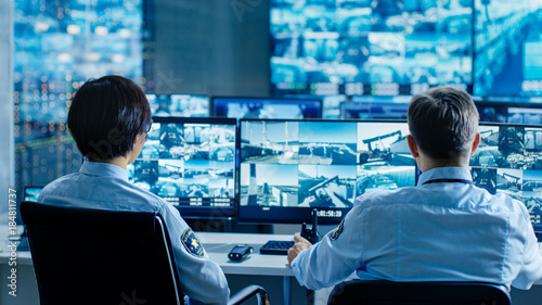 Fotografía In the Security Control Room Two Officers Monitoring Multiple Screens for Suspicious Activities, They Report any Unauthorised Activities