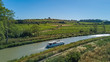 © Iuliia Sokolovska - Aerial top view of boat in Canal du Midi from above, family travel by barge and vacation in Southern France