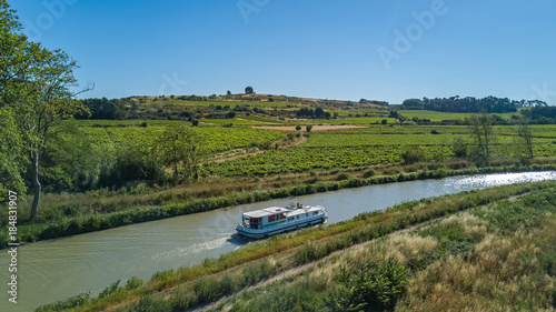 Cuadros en Lienzo Aerial top view of boat in Canal du Midi from above, family travel by barge and
