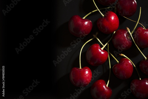 Fotomural Raw cherries on black background
