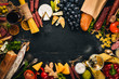© Yaruniv-Studio - A bottle of wine, cheeses and traditional sausages on a wooden background. Brie cheese, blue cheese, gorgonzola, fuete, salami. Free space for text. Top view.