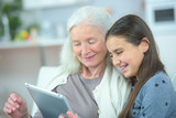 grandmother and granddaughter using tablet