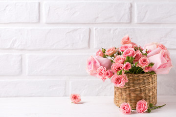 Wall Mural - Background with pink roses flowers  against  white brick wall.