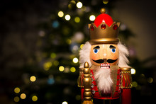 Christmas Nutcracker With Christmas Tree And Lights In Background